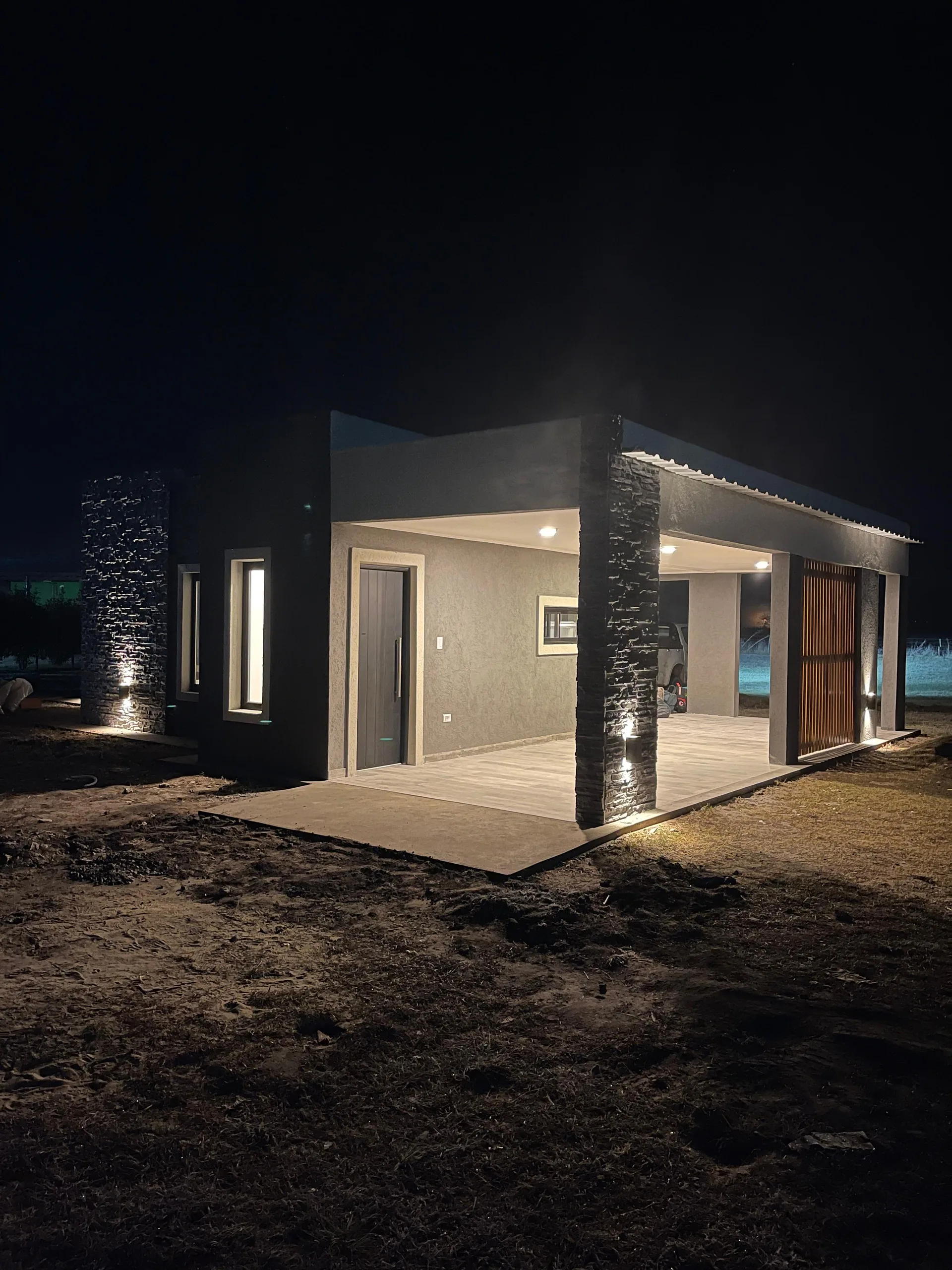 Vivienda construida por Durma, fotografiada de noche con la fachada iluminada
